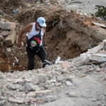 Un voluntario camina entre escombros de un edificio derrumbado en La Guaira (Venezuela). EFE/ Ronald Peña R.