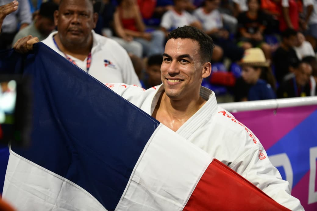 Larry Aracena sostiene la bandera de República Dominicana luego de ganar la medalla de oro en las pruebas de kata masculino de los Juegos Centroamericanos y del Caribe 2026.