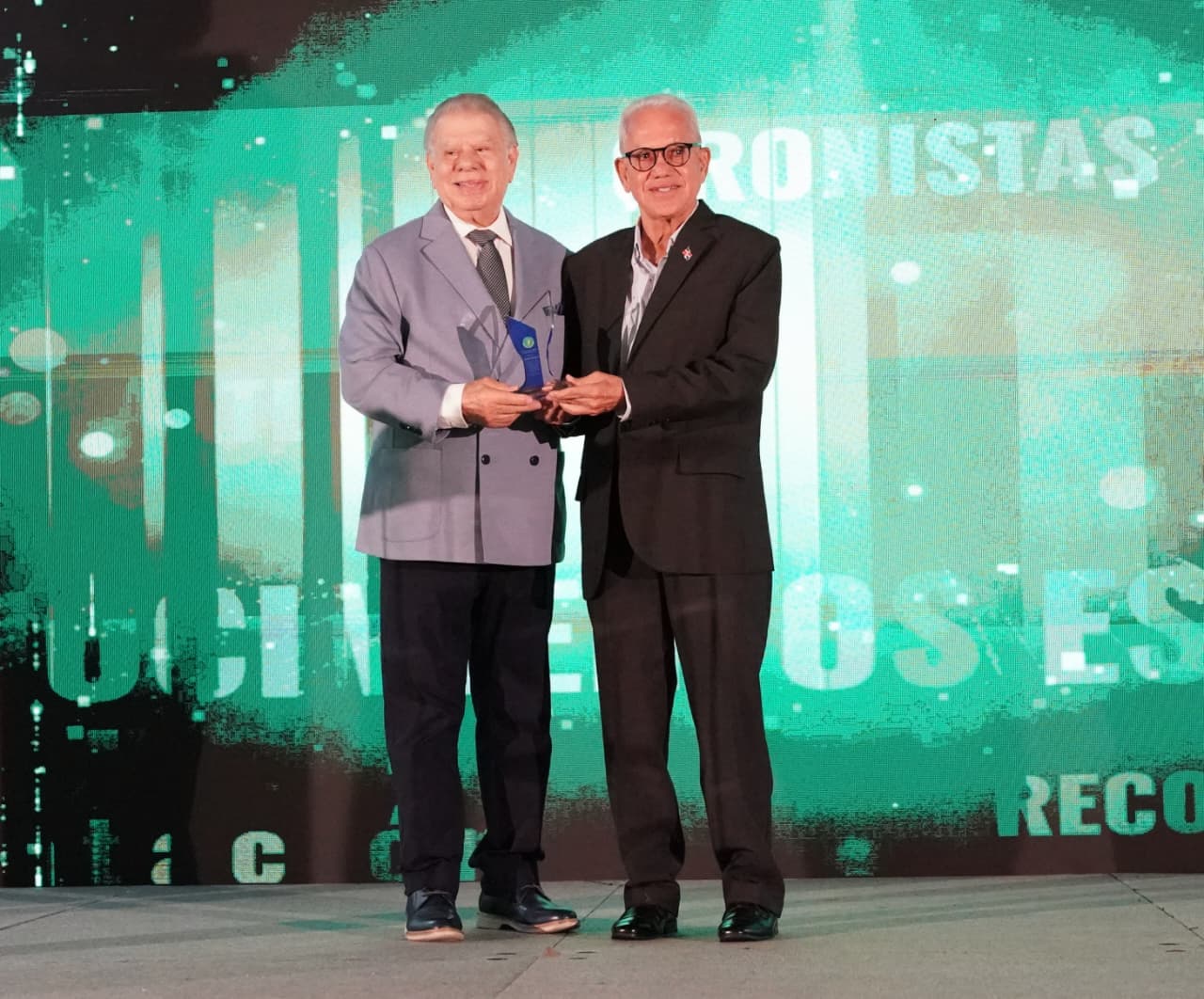 Rolando Sebelén entrega reconocimiento al periodista Gustavo Rodríguez.