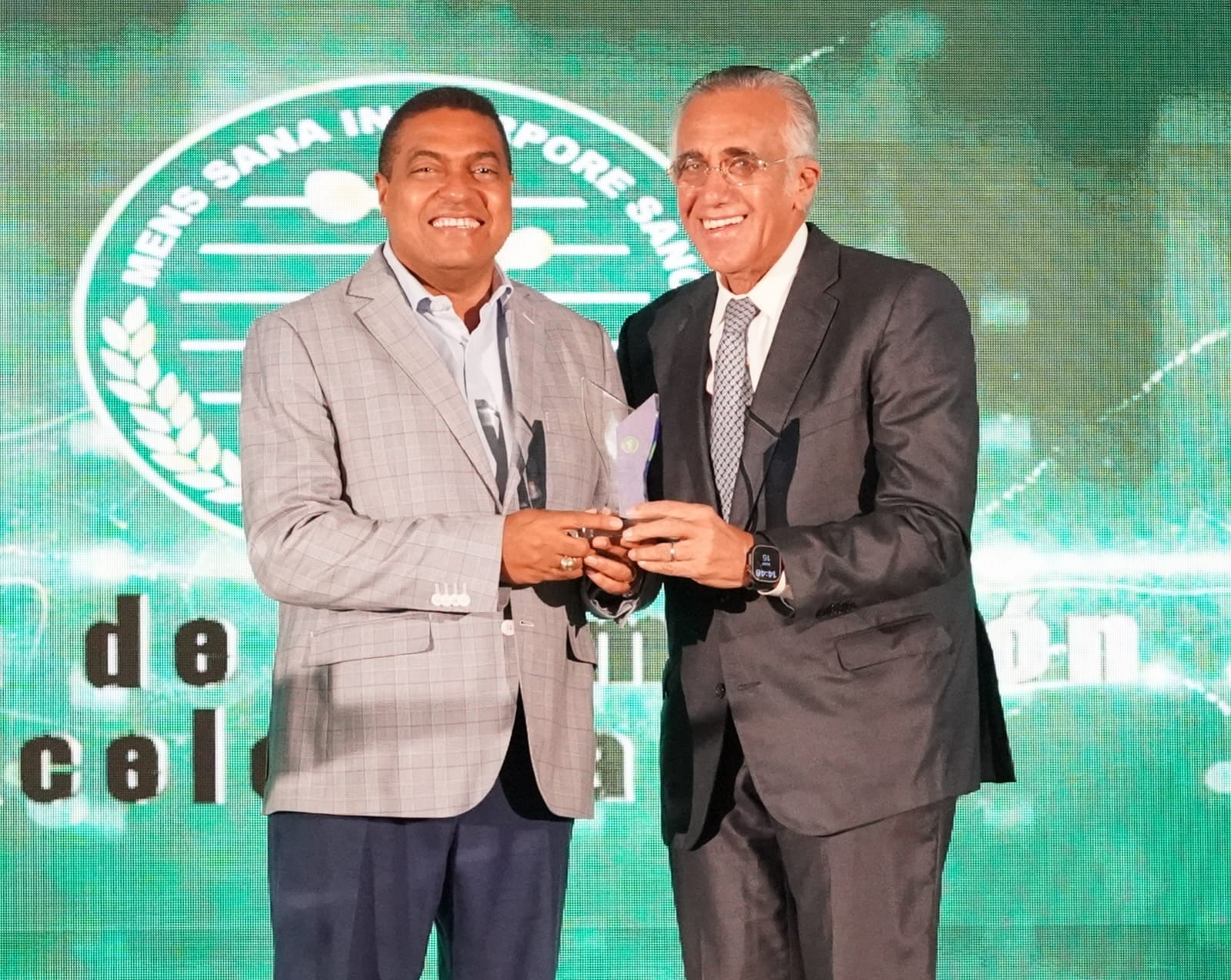 José P. Monegro recibe de manos de Luis Mejía un reconocimiento por su gestión.